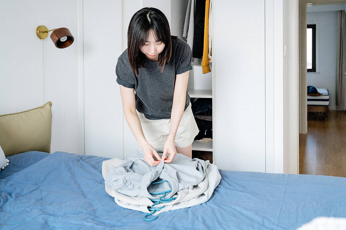Young woman folding her laundry at home