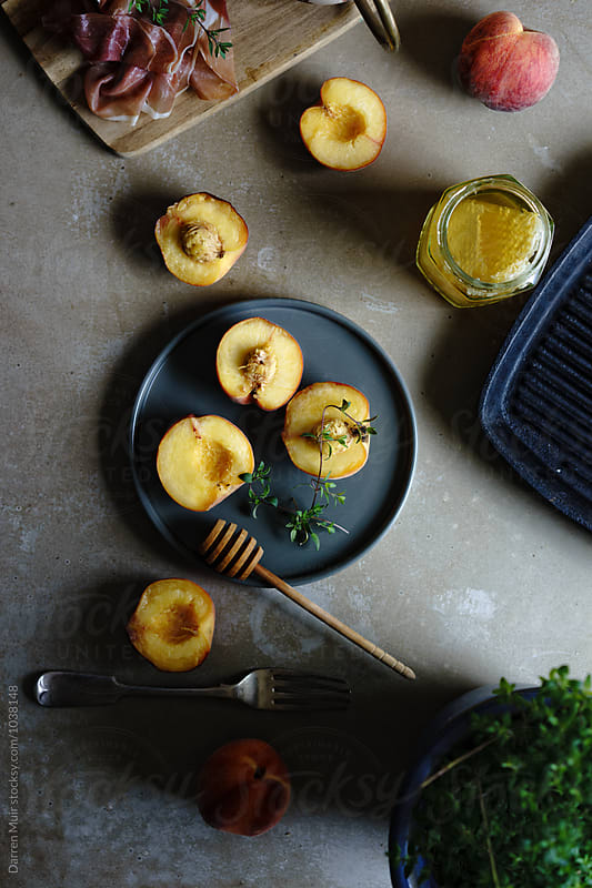 Peaches and ingredients for preparing them on a work-surface.