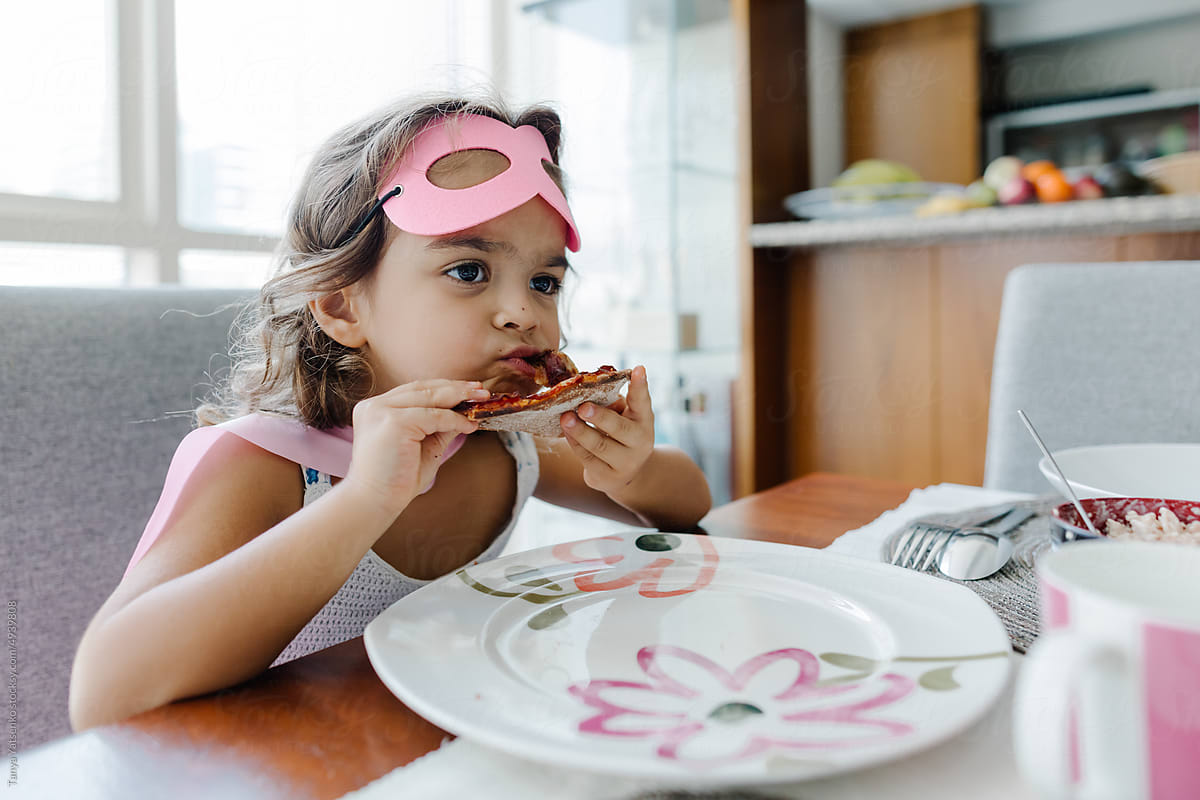 A girl eating pizza at home
