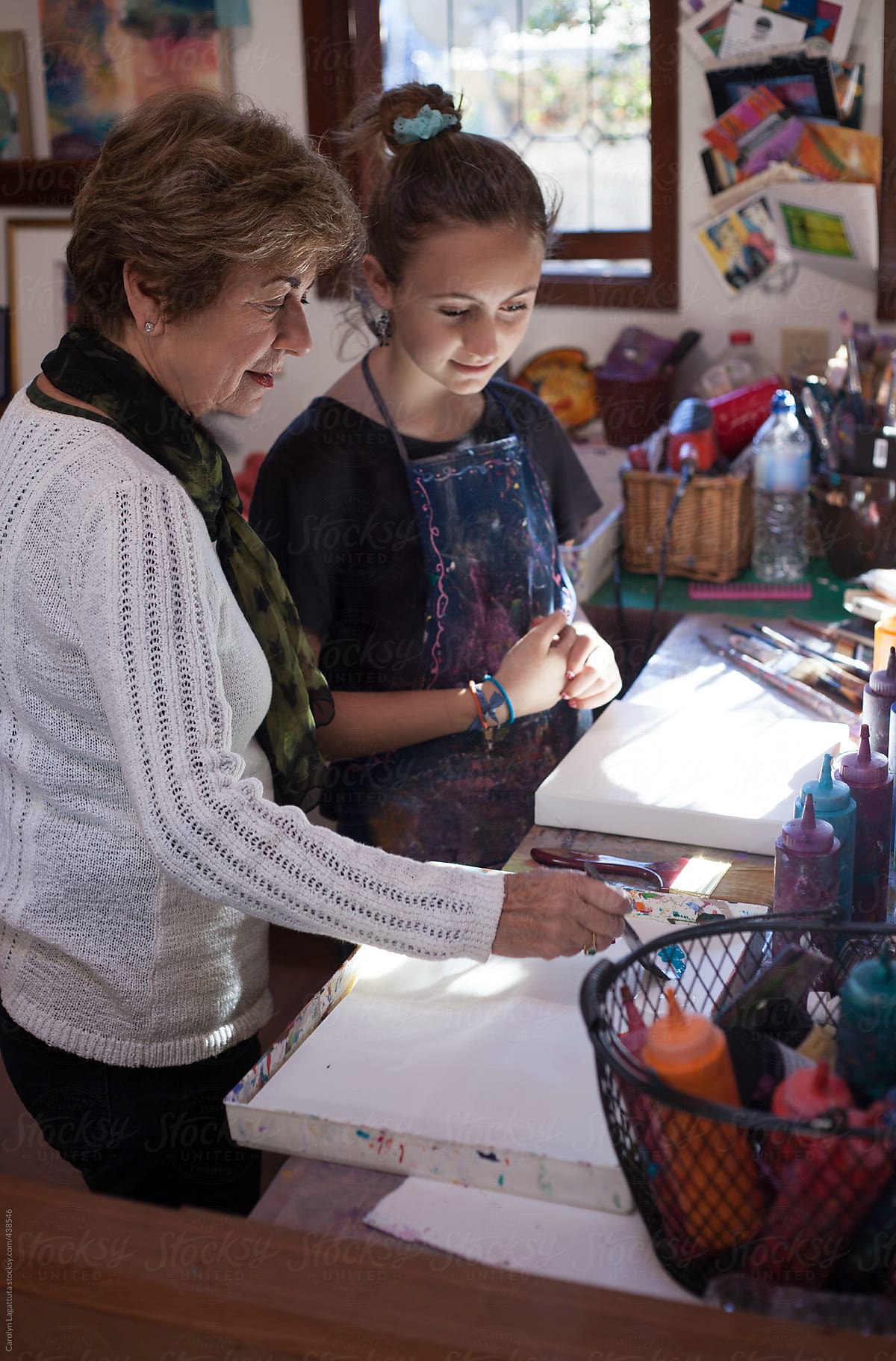 Teen girl and her grandmother having an art lesson in their home studio