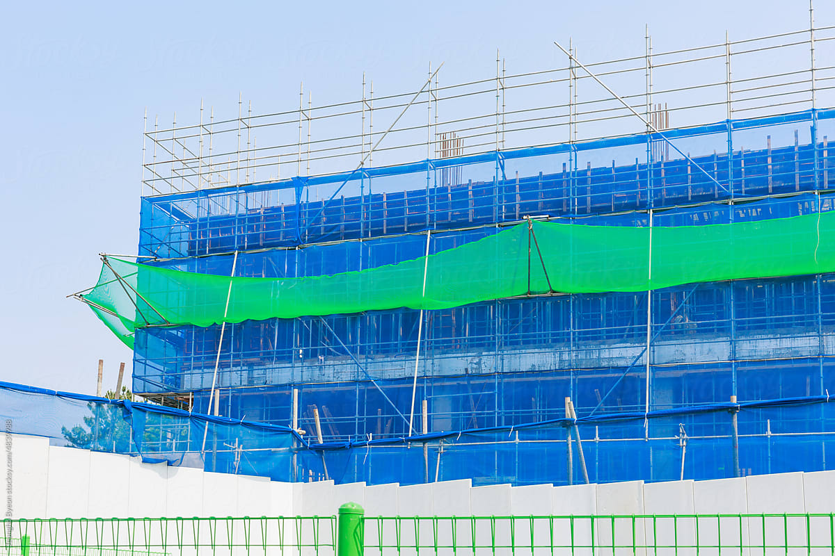 A blue safety net is installed at the construction site.