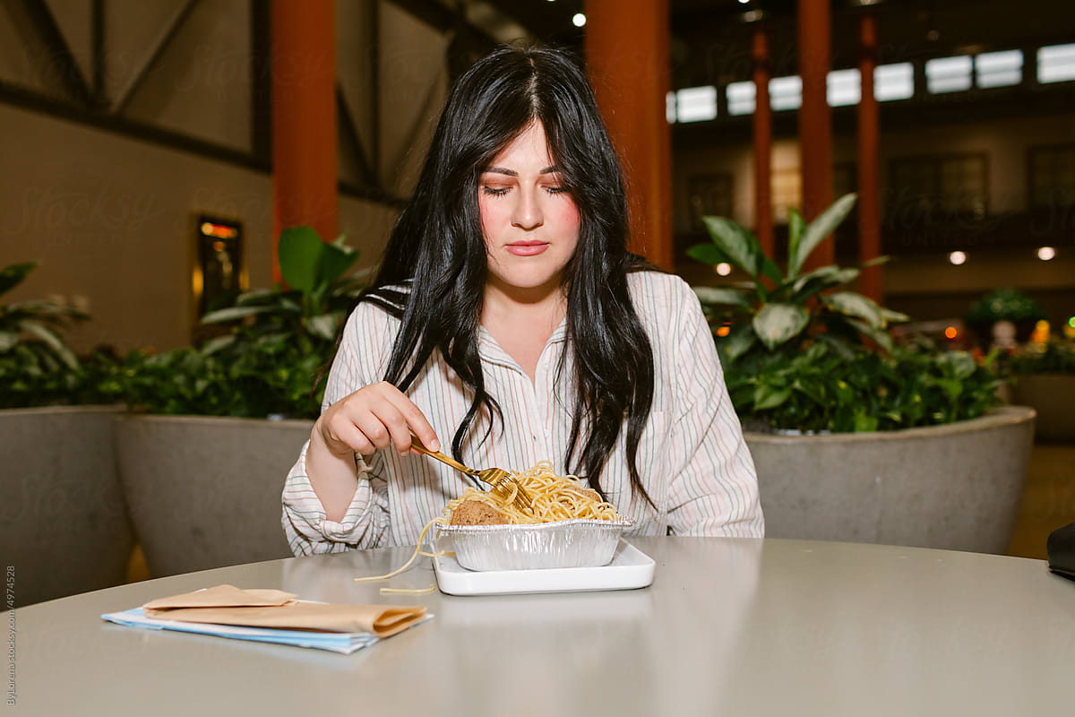 Woman eating pasta without excitement