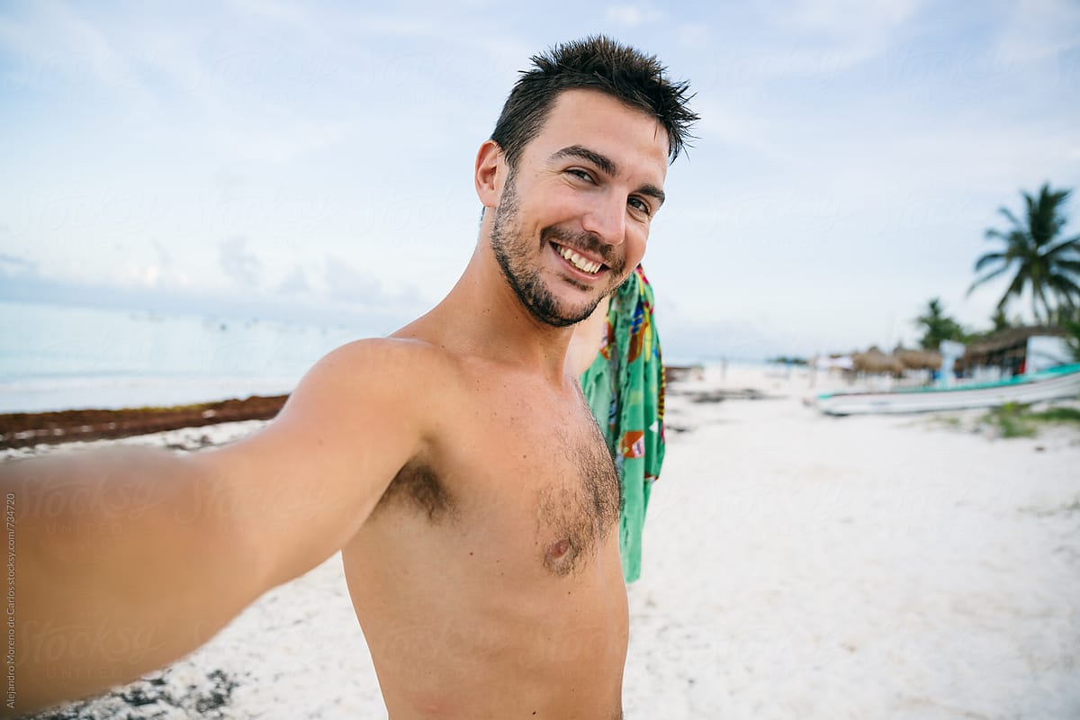 Young Man Taking A Selfie In A Tropical Beach At Sunset By Stocksy Contributor Alejandro