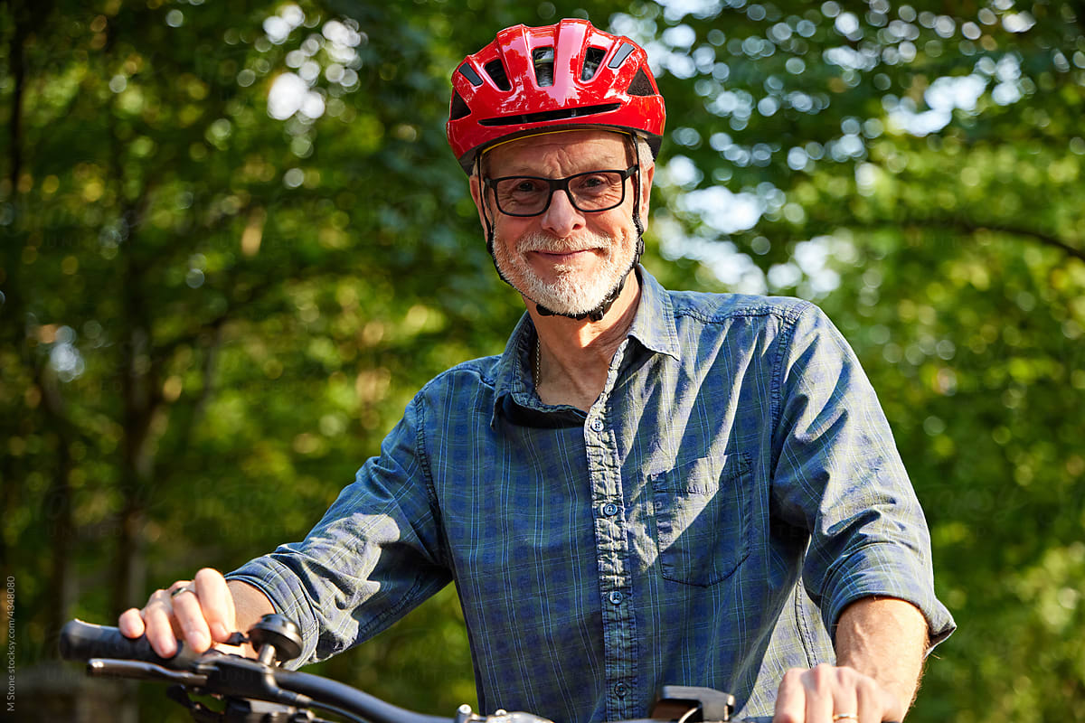 Older Man with glasses rides Mountain bike on leisure cycle