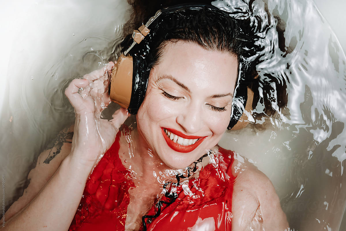 Happy woman in bath with headphones