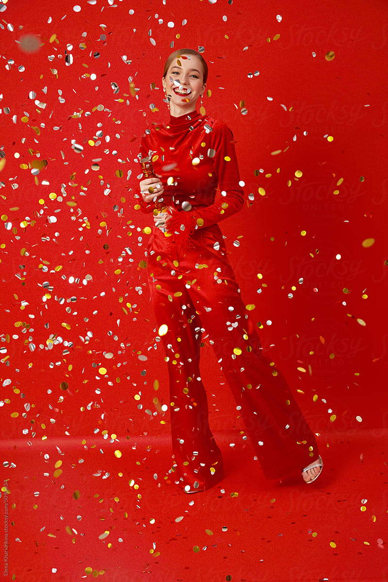 Happy woman with confetti on a red background