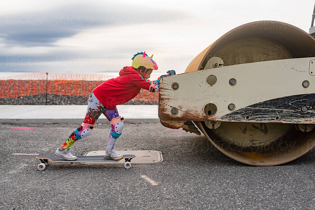 Determined skateboarder pushes on steamroller