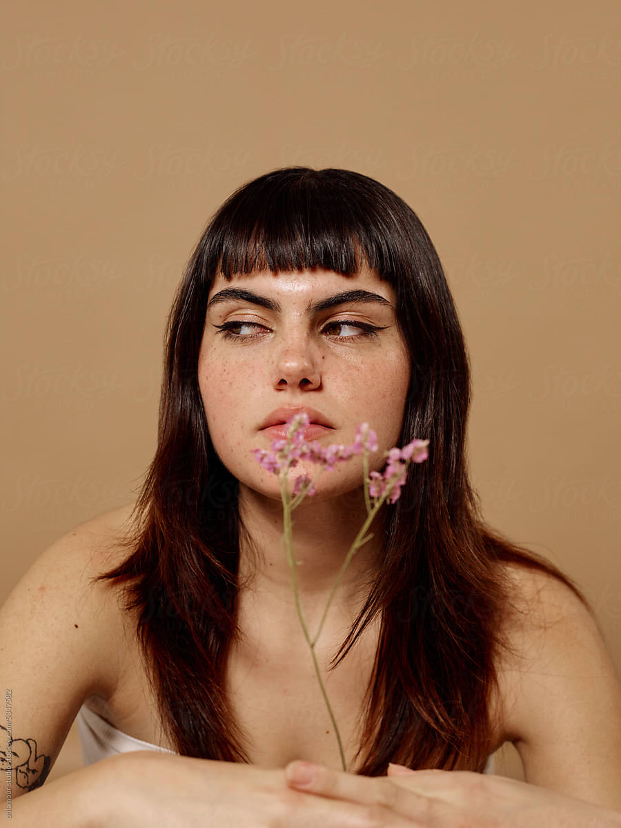 Soft skin woman giving side eye and holding flowers