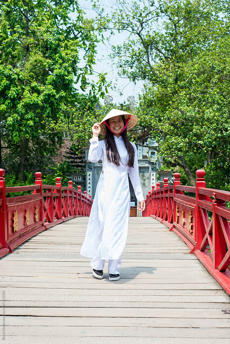 Optimistic Asian female walking on bridge