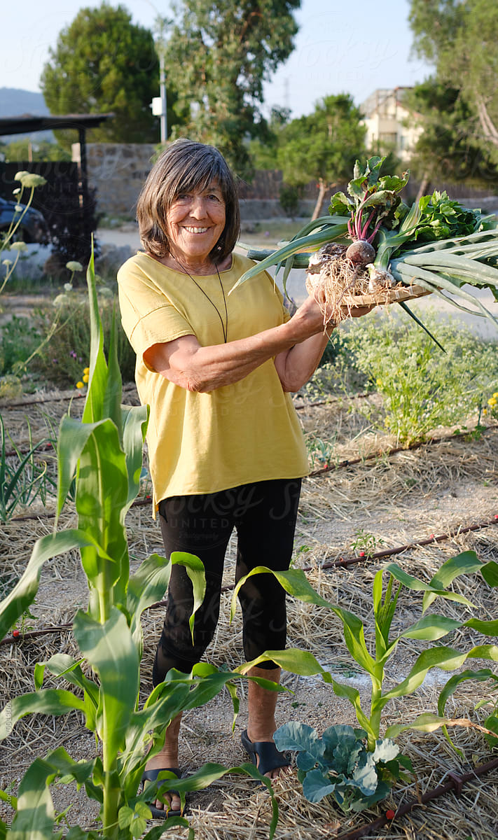 Happy Senior woman showing garden harvest smiling