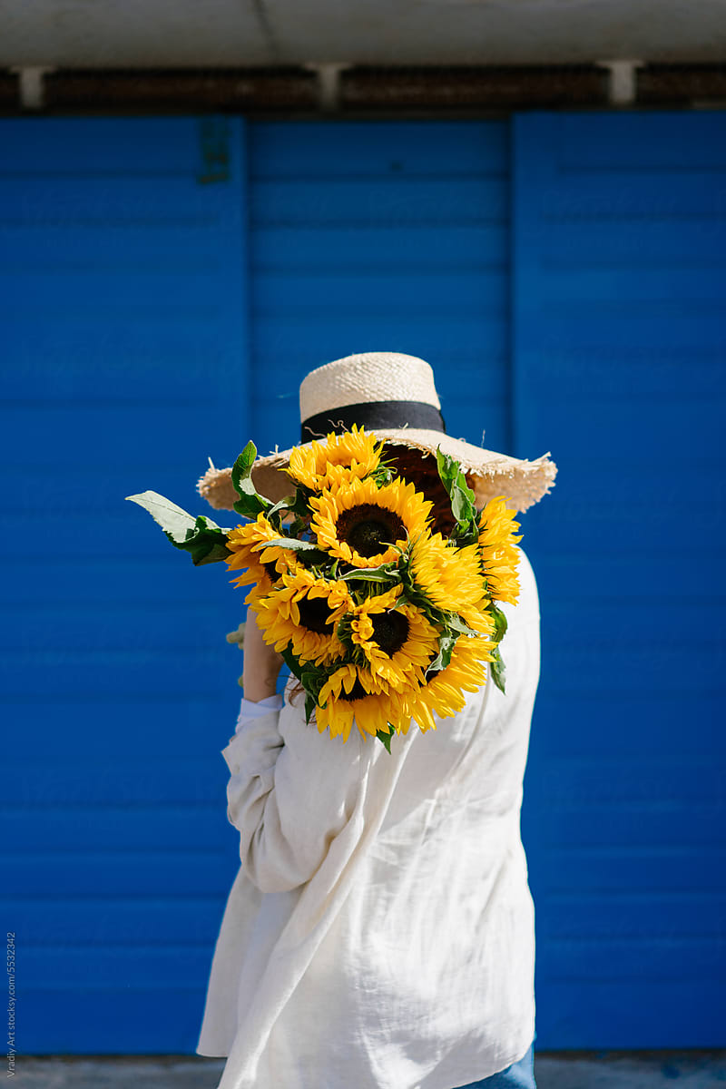 Woman holds a bouquet of fresh sunflowers