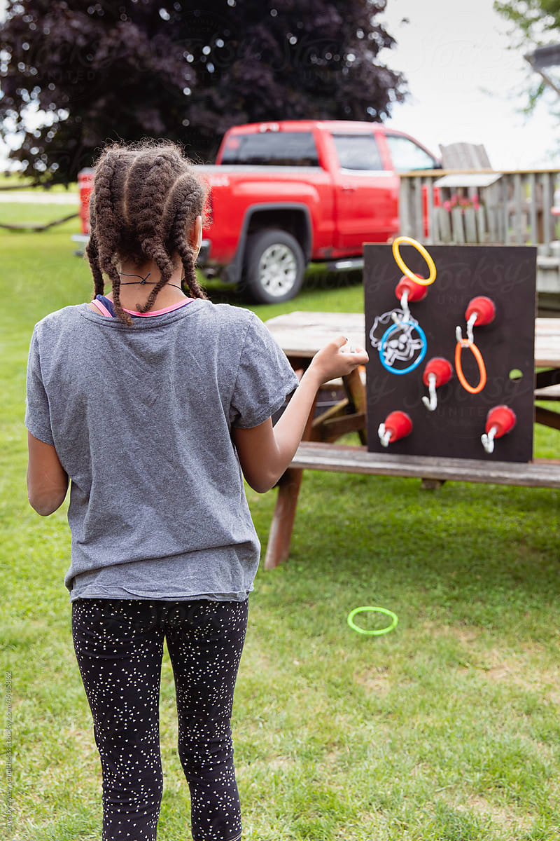 Child throwing rings at a target filled with pirate hand hooks