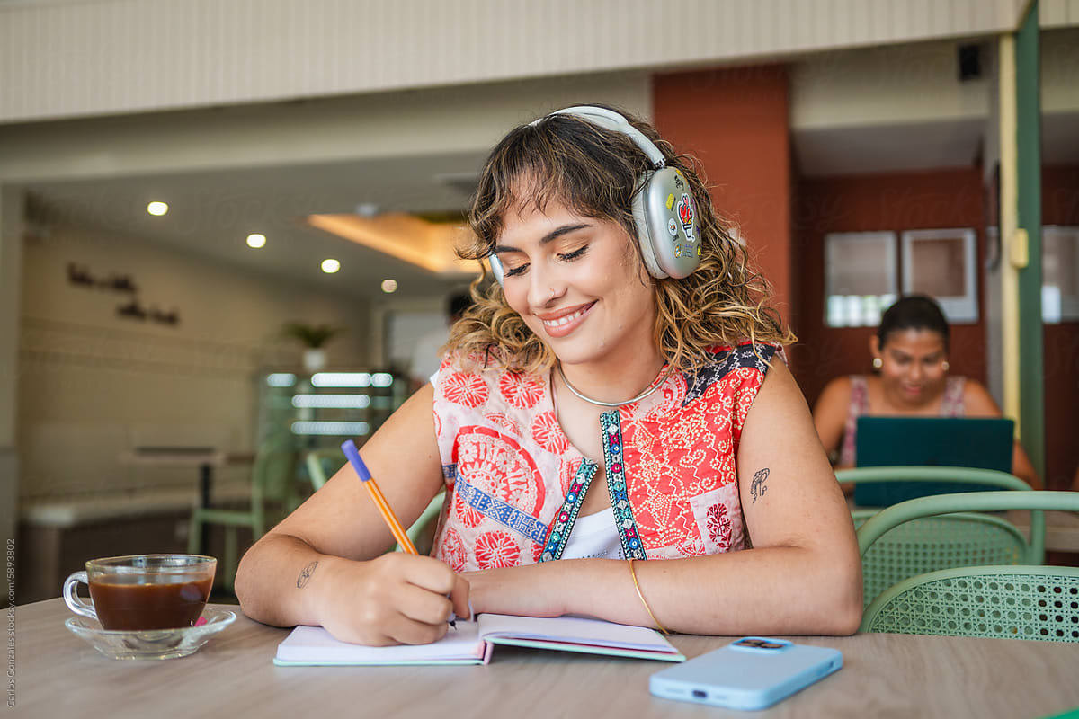 Smiling Woman With Headphones Writing