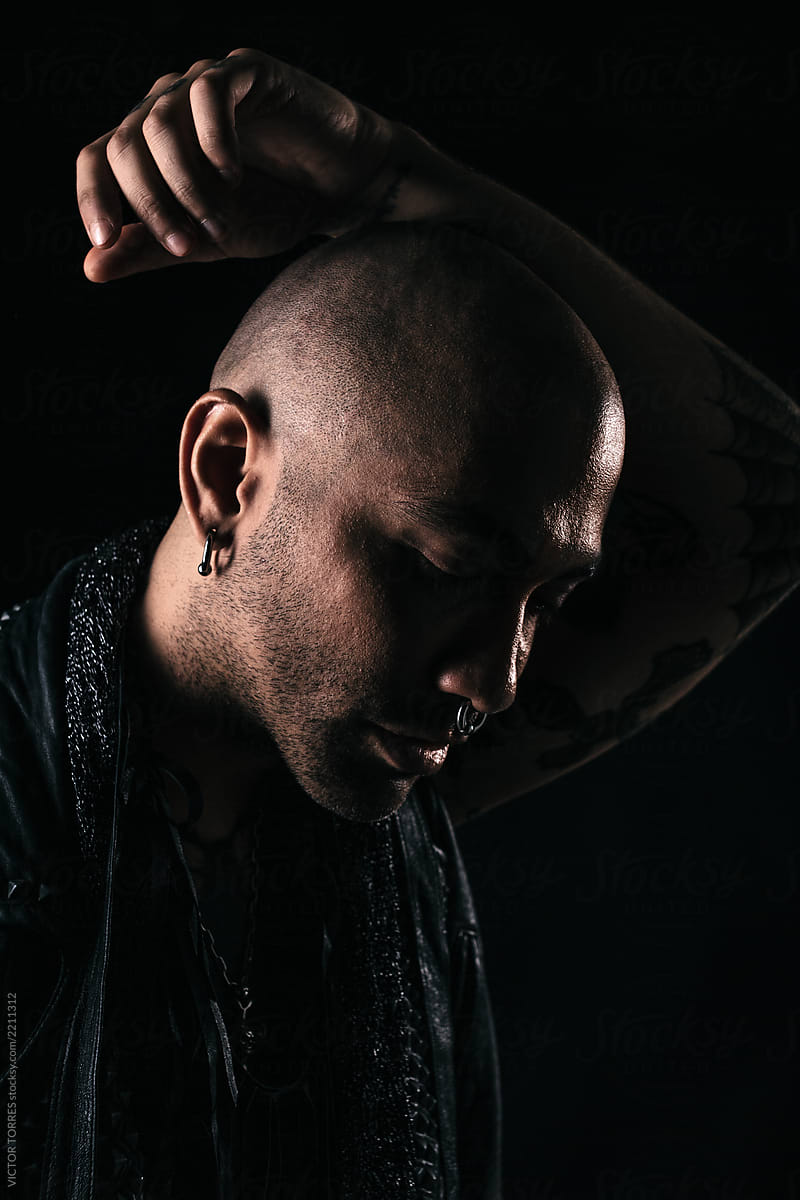Rough tattooed man portrait over black background