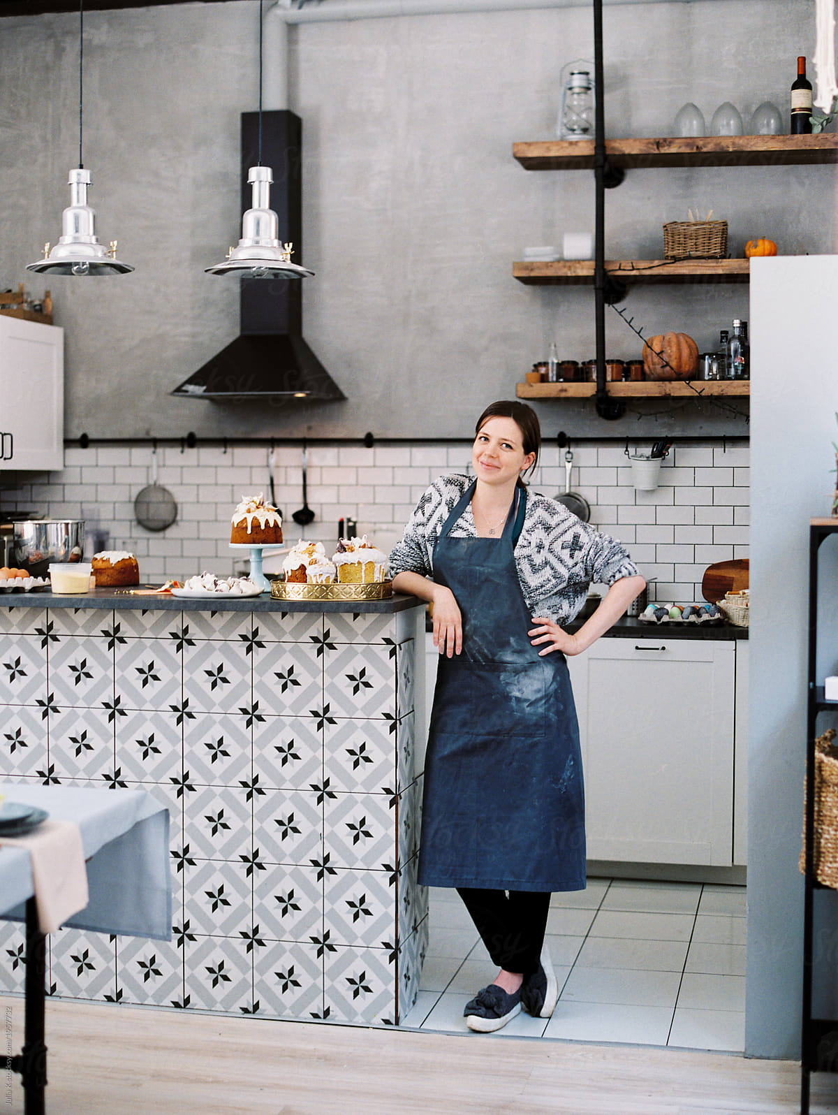 Woman with cakes on counter in kitchen