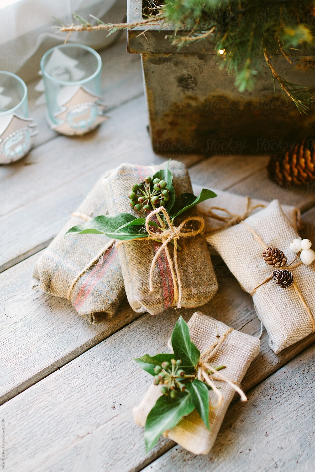 Linen and tartan-wrapped gifts under a Christmas tree