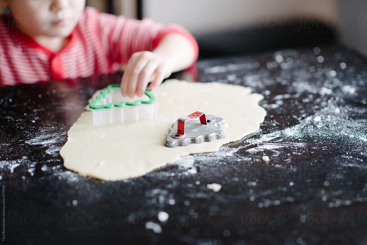 little boy makes tree shaped sugar cookies with new and old cutters