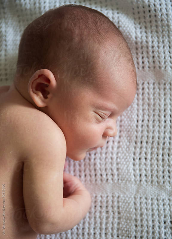Profile of a newborn baby sleeping on a blanket
