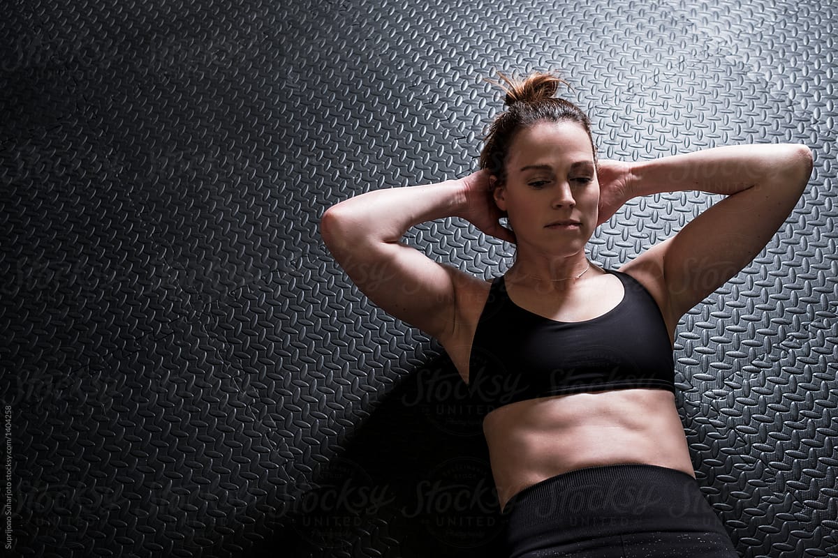 Woman Doing Sit Ups In The Home Gym by Stocksy Contributor Take