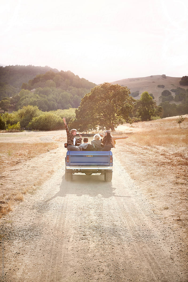 Friends driving down a dirt road on a road trip