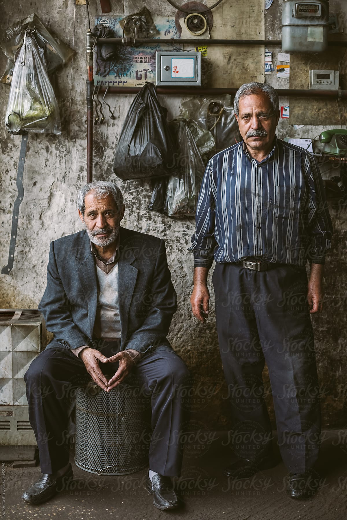 portrait of two male iranian seniors in their garage