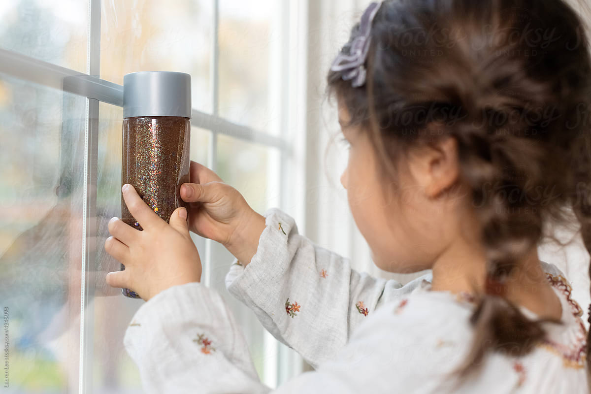 Little girl looking at glitter jar