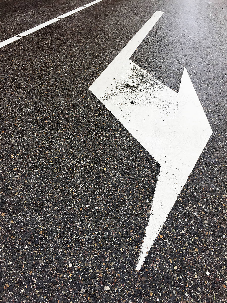 arrow on wet asphalt road