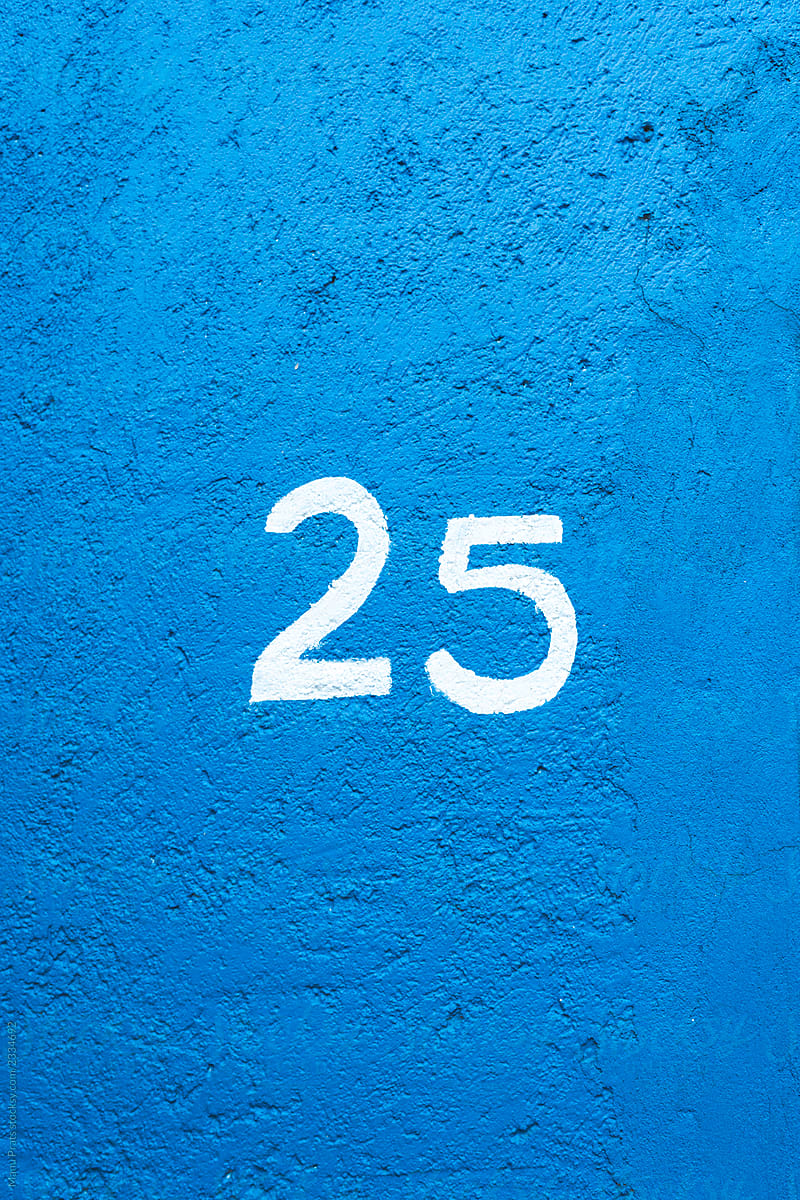 Number twenty five on painted blue wall of house