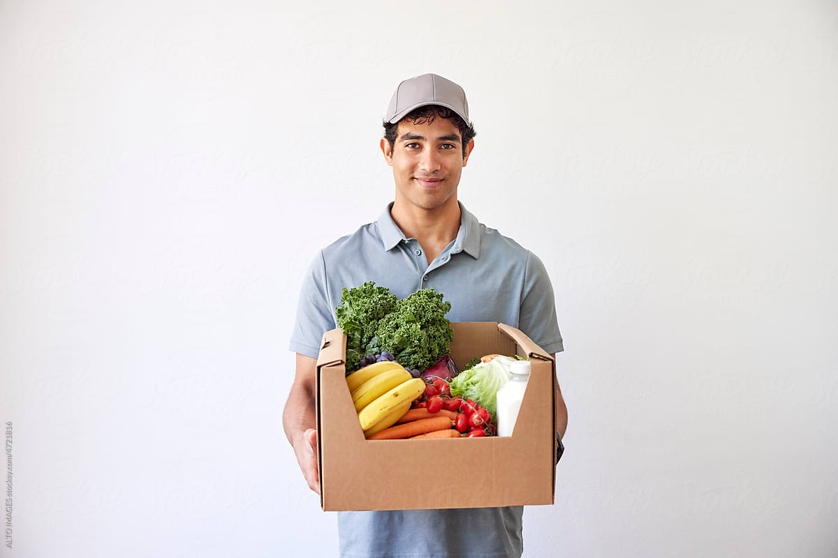 Positive courier with box of healthy food