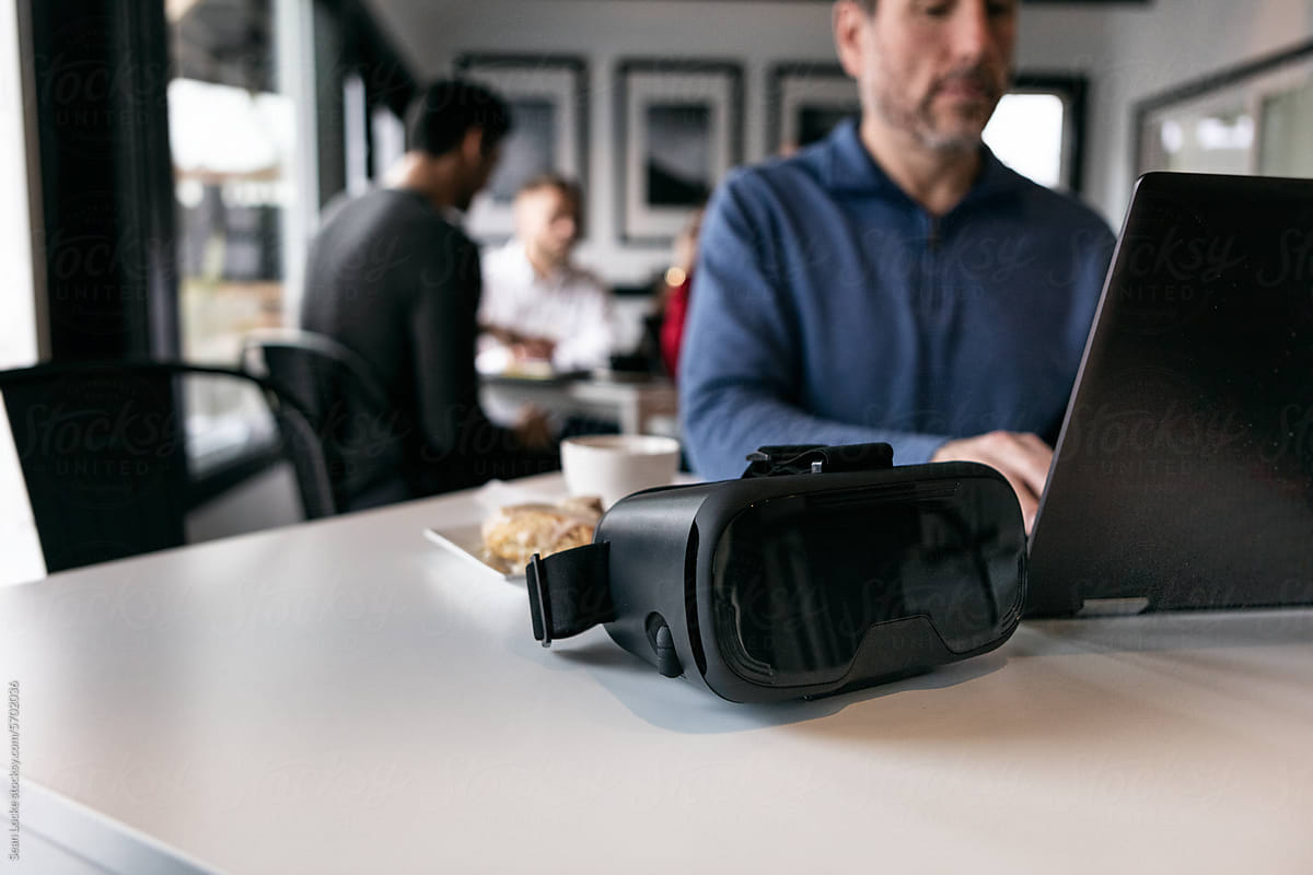 Business: Focus On VR Headset On Table As Man Works