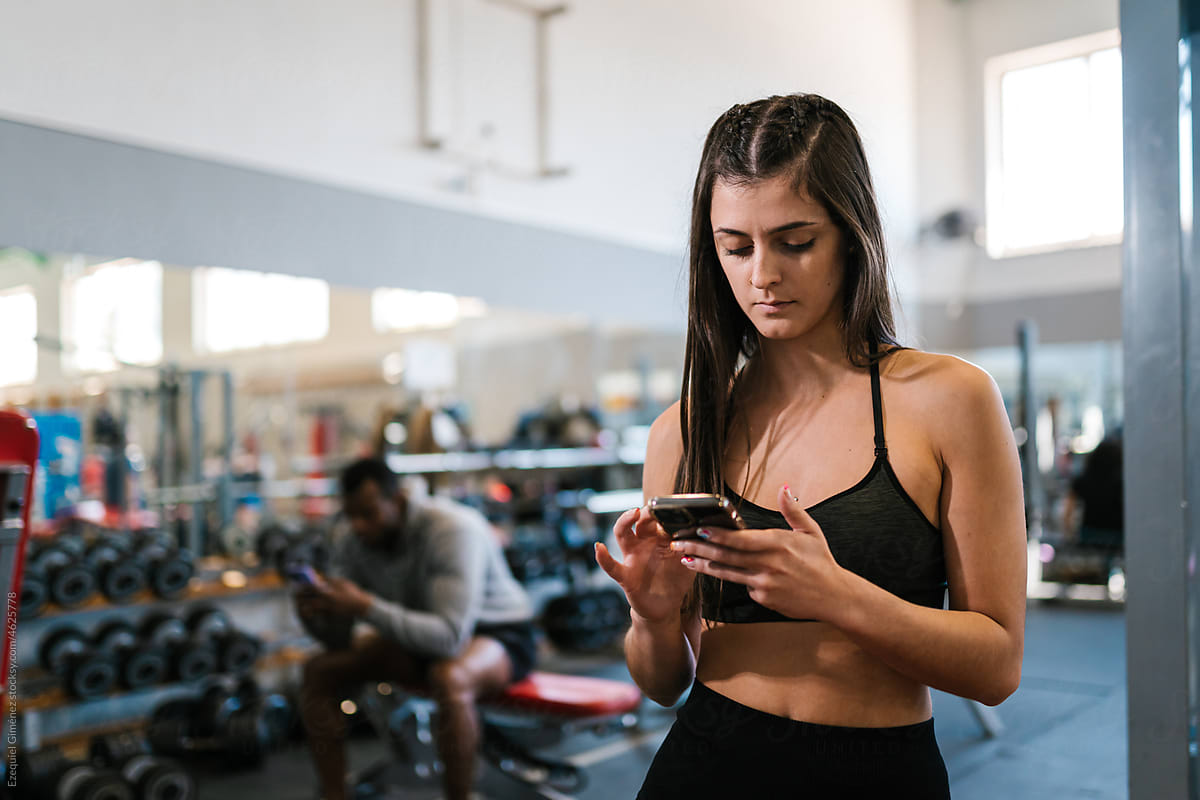 Sportswoman using mobile phone in gym