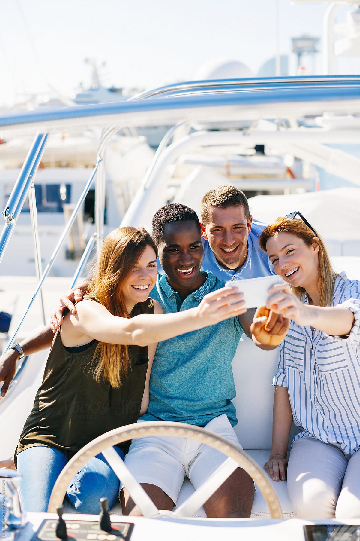 Group of young friends taking a selfie on a luxurious yacht.