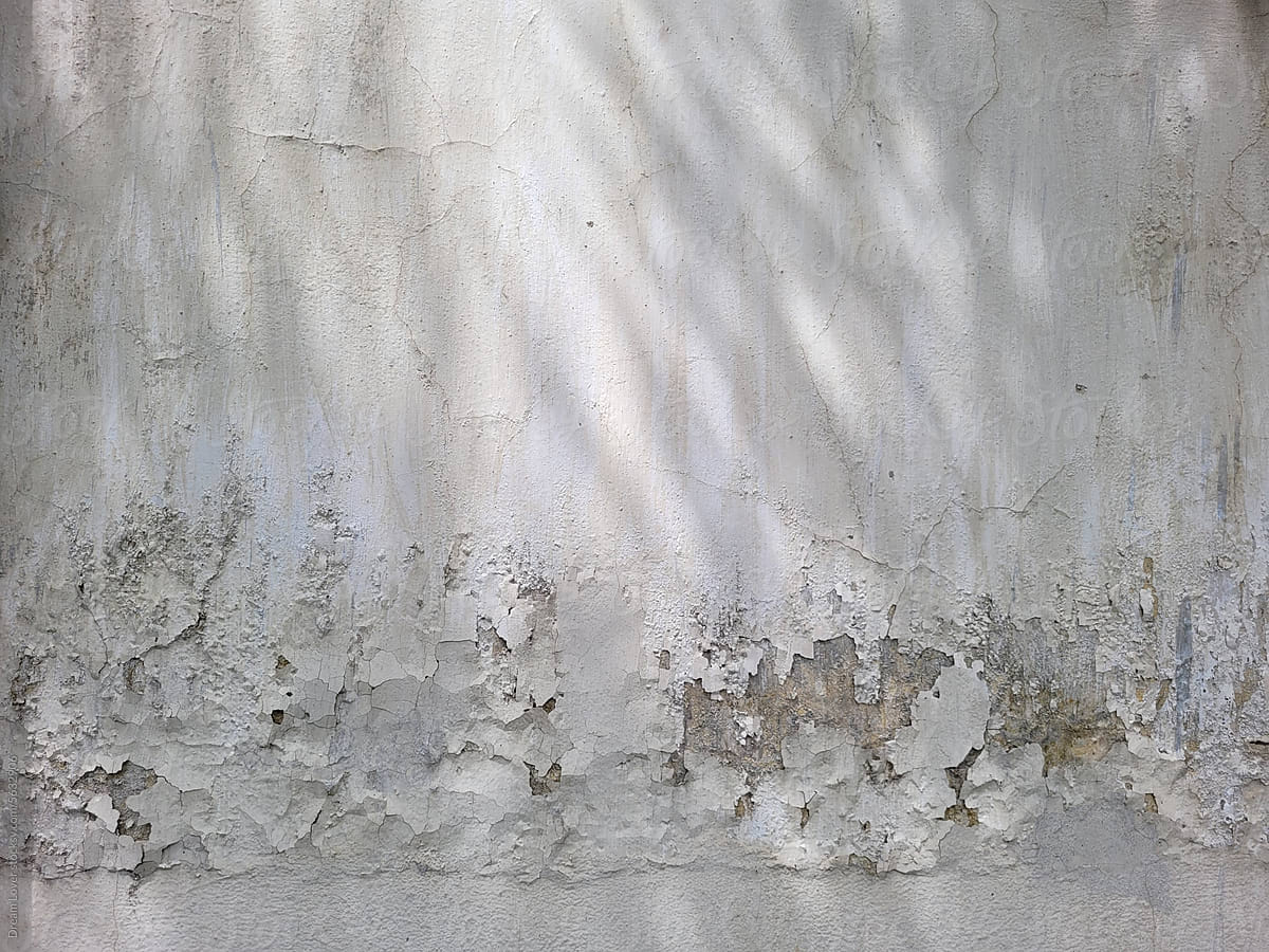 Sunlight fall on cemented wall of a house with worn out paint