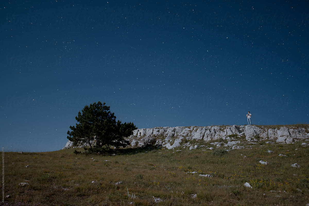 Mountain plateau with figure of man at starry night