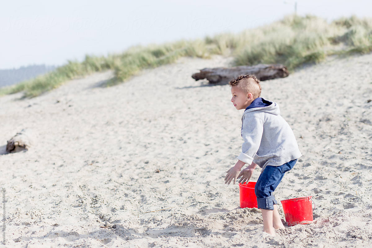 Boy looks to sea on sandy beach