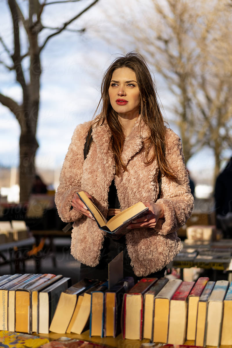 A woman leafing through a book at a used book market
