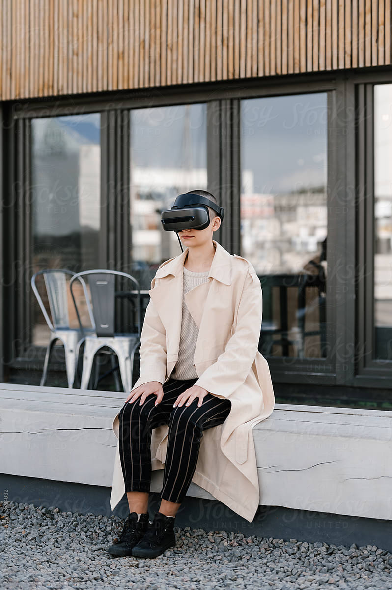 Young woman in VR headset sitting on bench