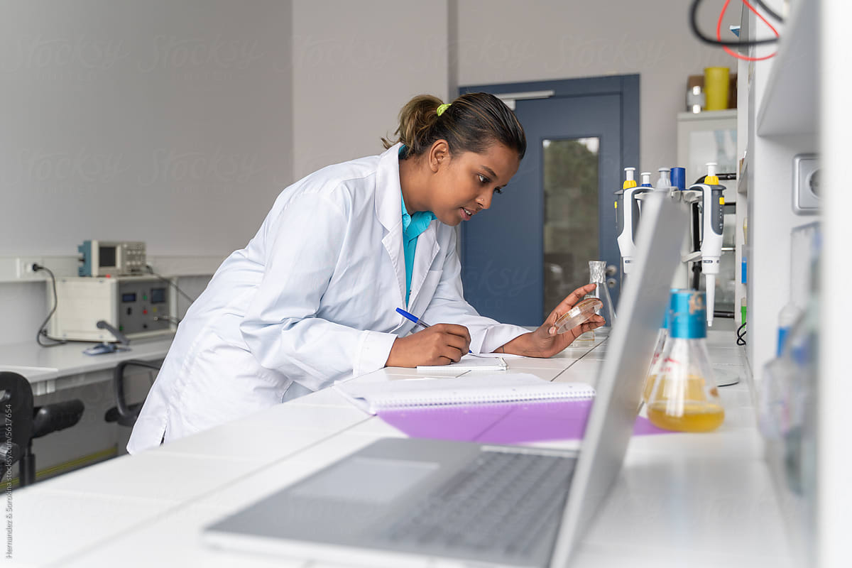 Scientist Holding Sample And Writing Notes