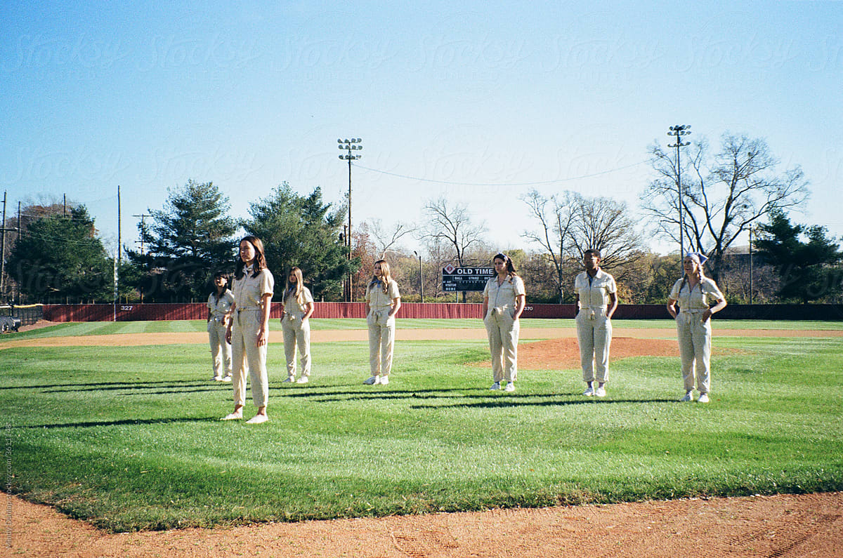 Young women standing in formation on a baseball field