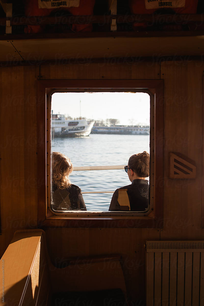 Tourists in Istanbul seen through a ferryboat window.