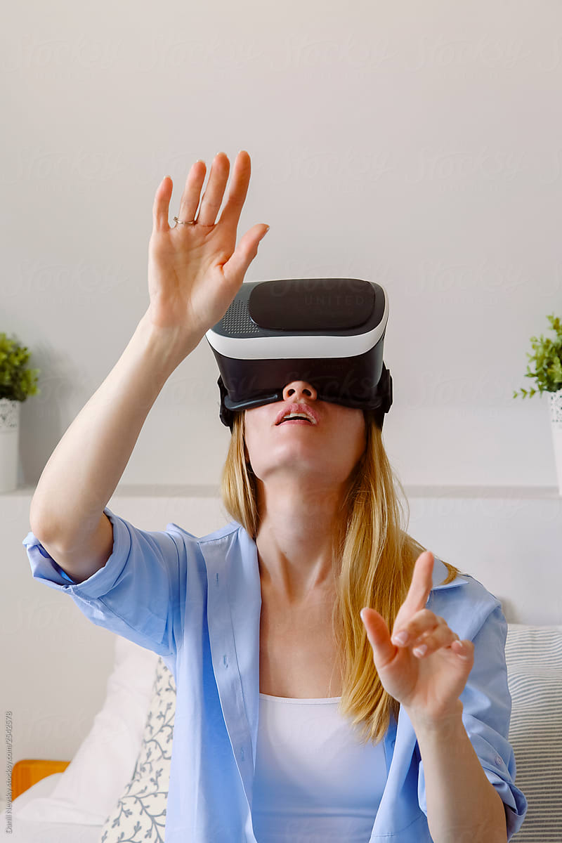 Amazed woman in VR glasses looking up