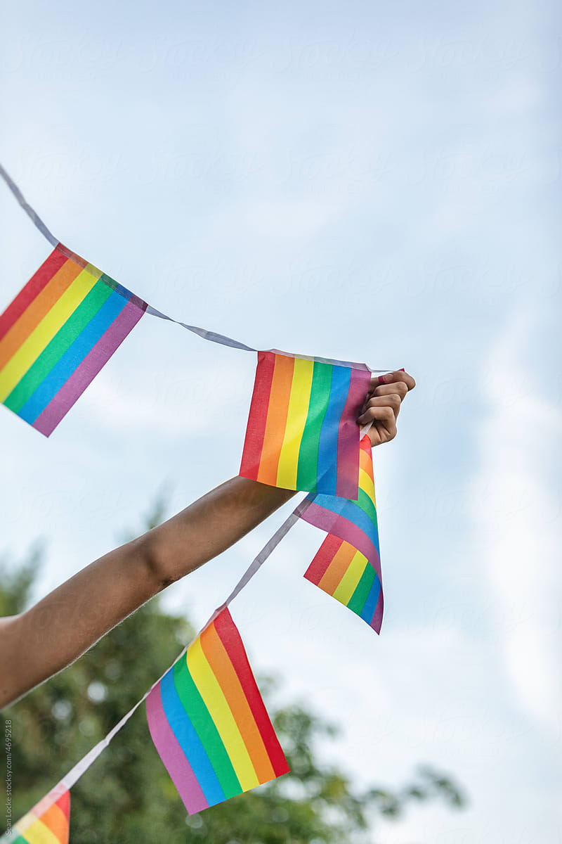 Woman Holding Up LGBTQ+ Pride Flag Banner