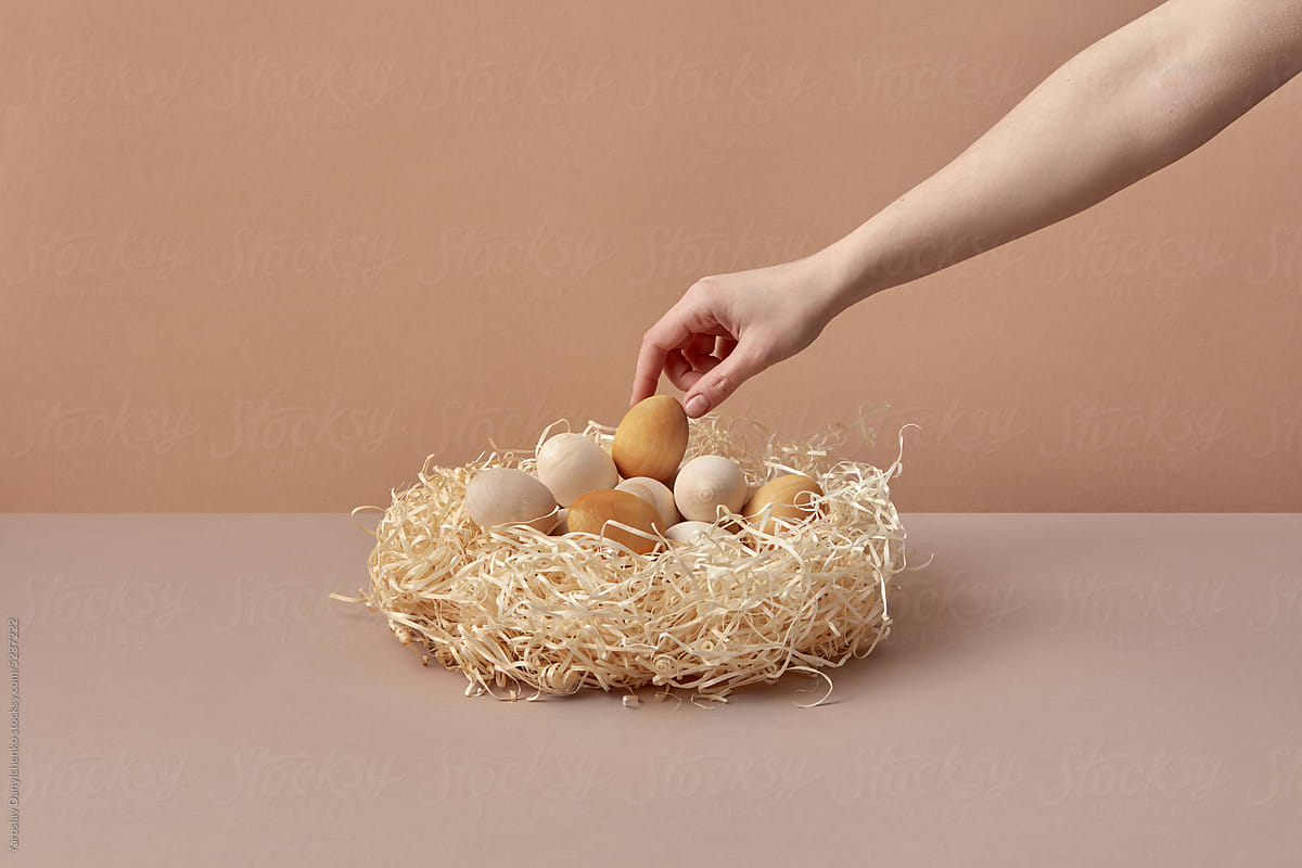 Wooden Easter eggs taken by woman from nest.