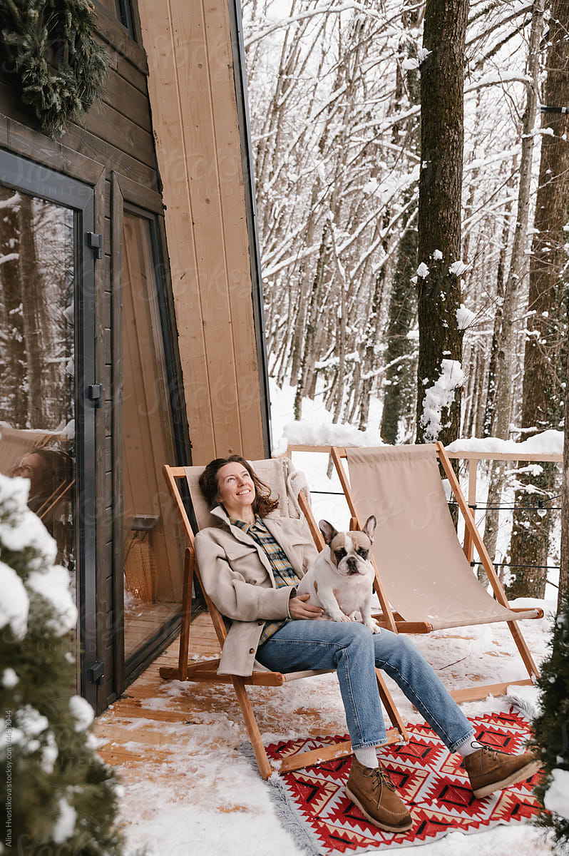 Relaxed woman with french Bulldog sitting in deckchair