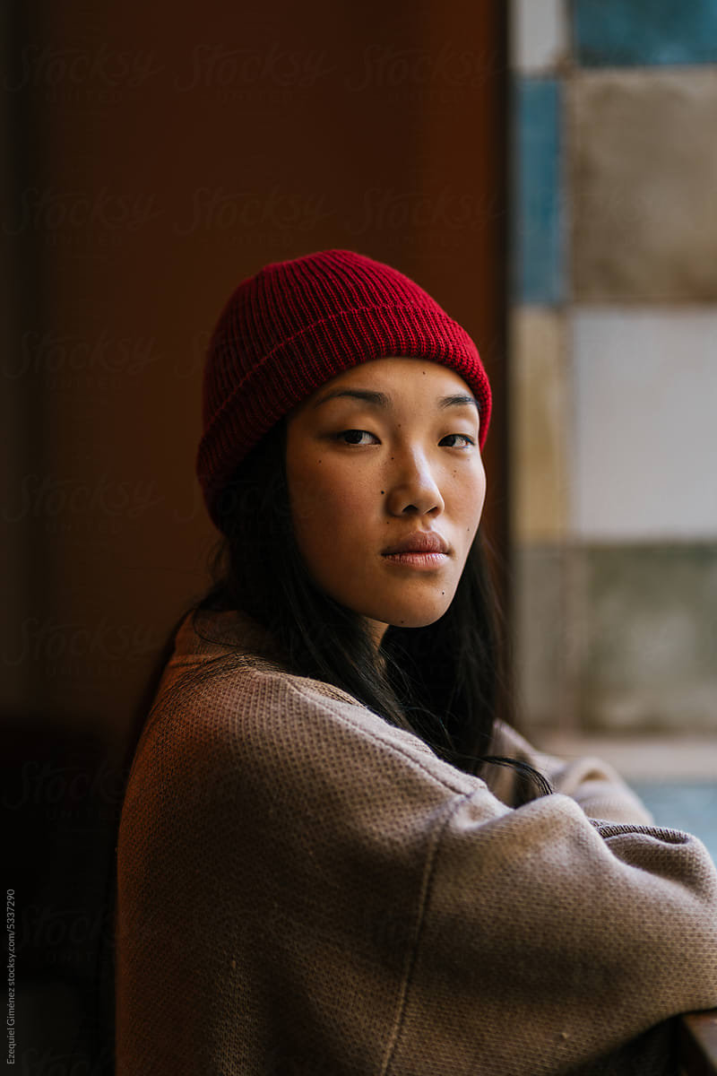 Stylish woman wearing beanie and looking at camera