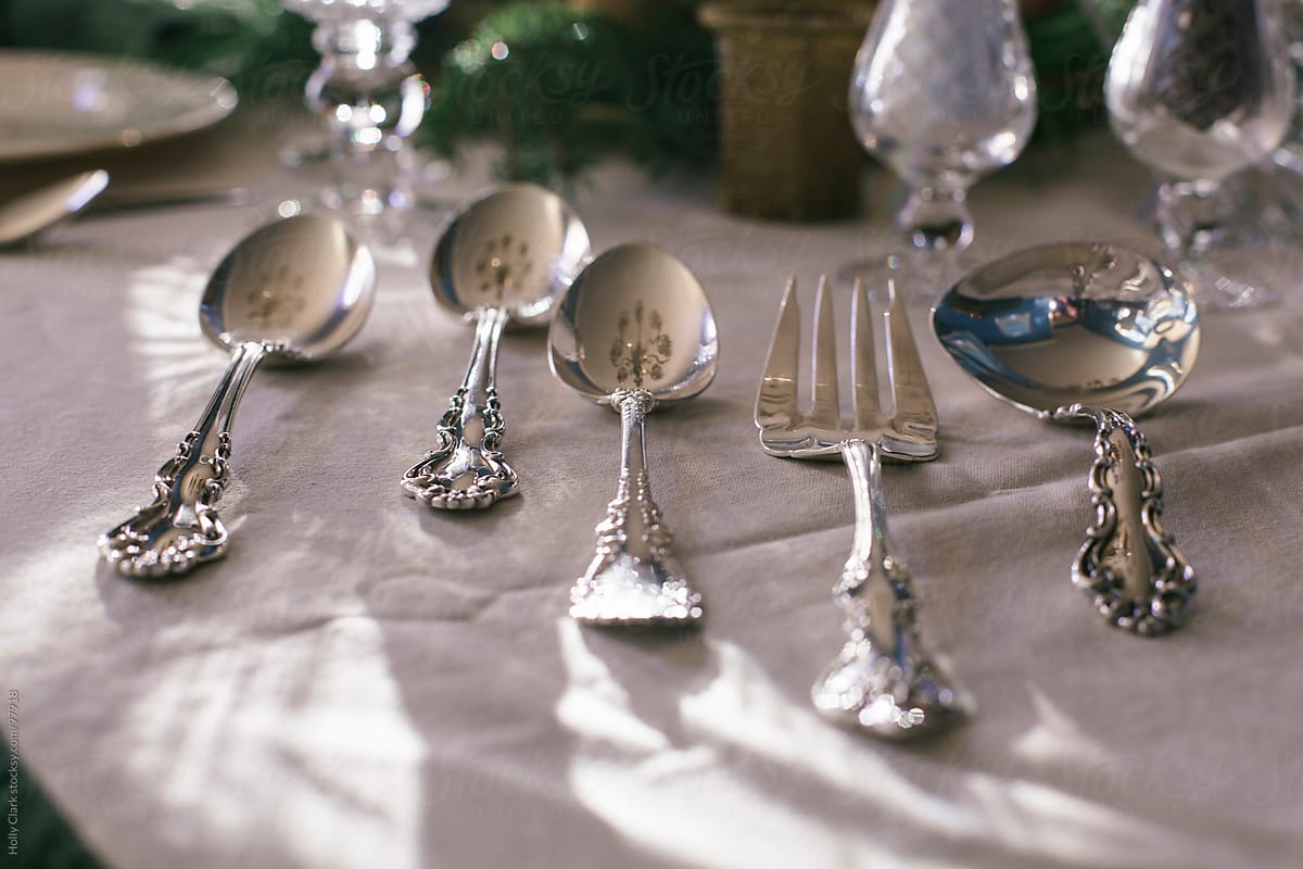 Silver serving utensils on tablecloth at Thanksgiving