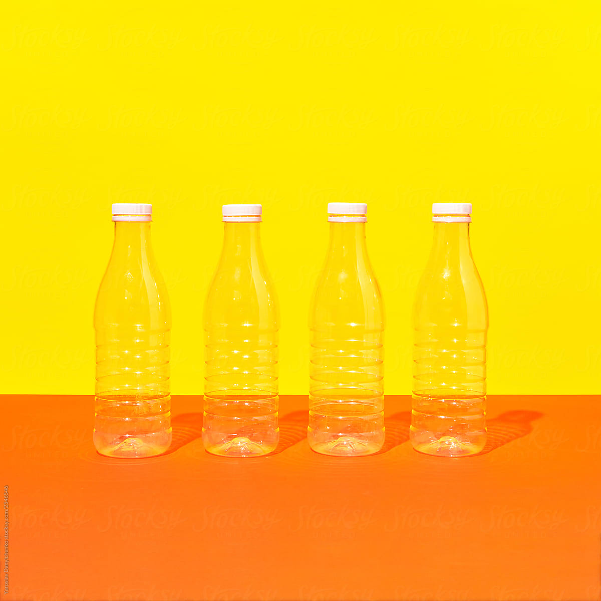 Plastic bottles on a double yellow orange background