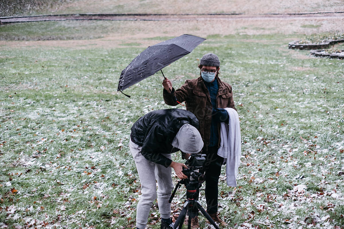 Camera operator and director filming in a field