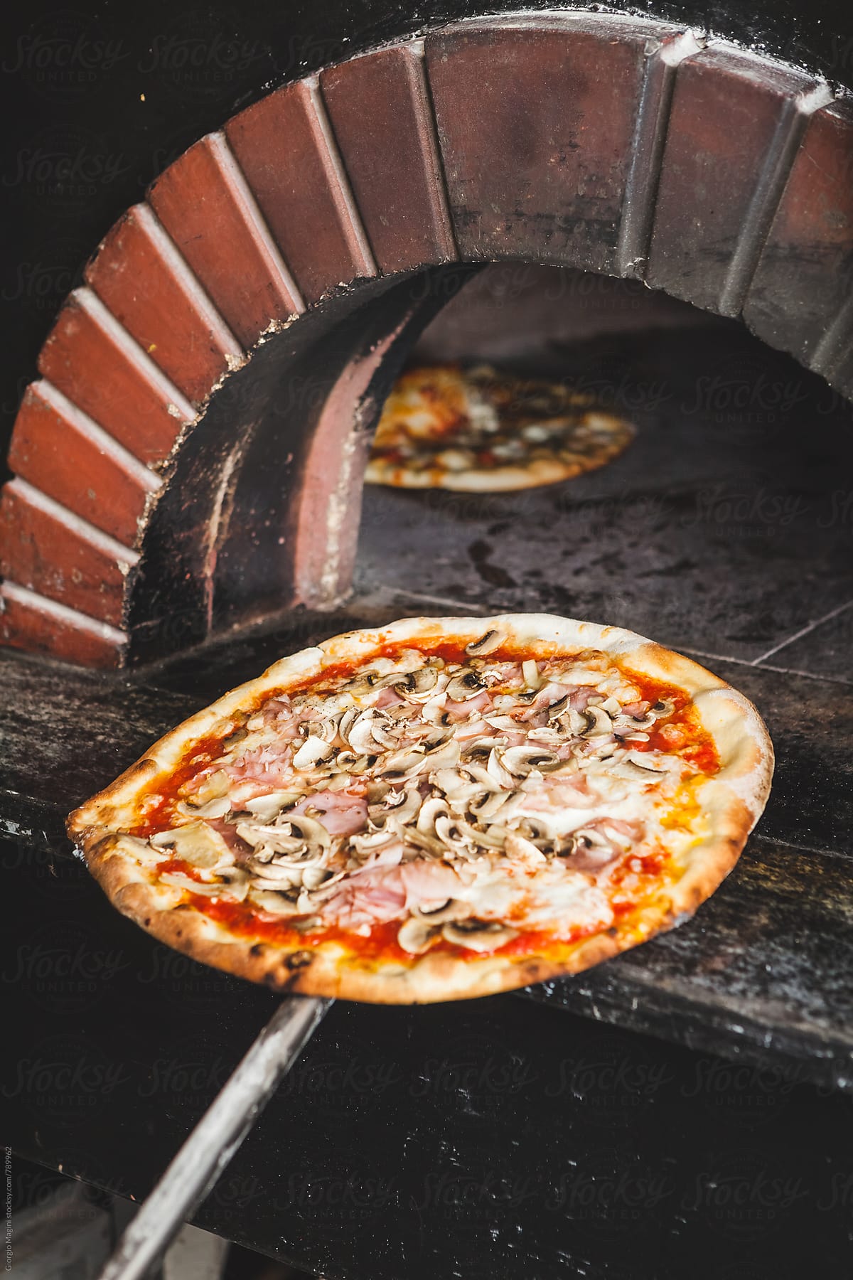 Baked Pizza on a Peel in front of a Wood Oven