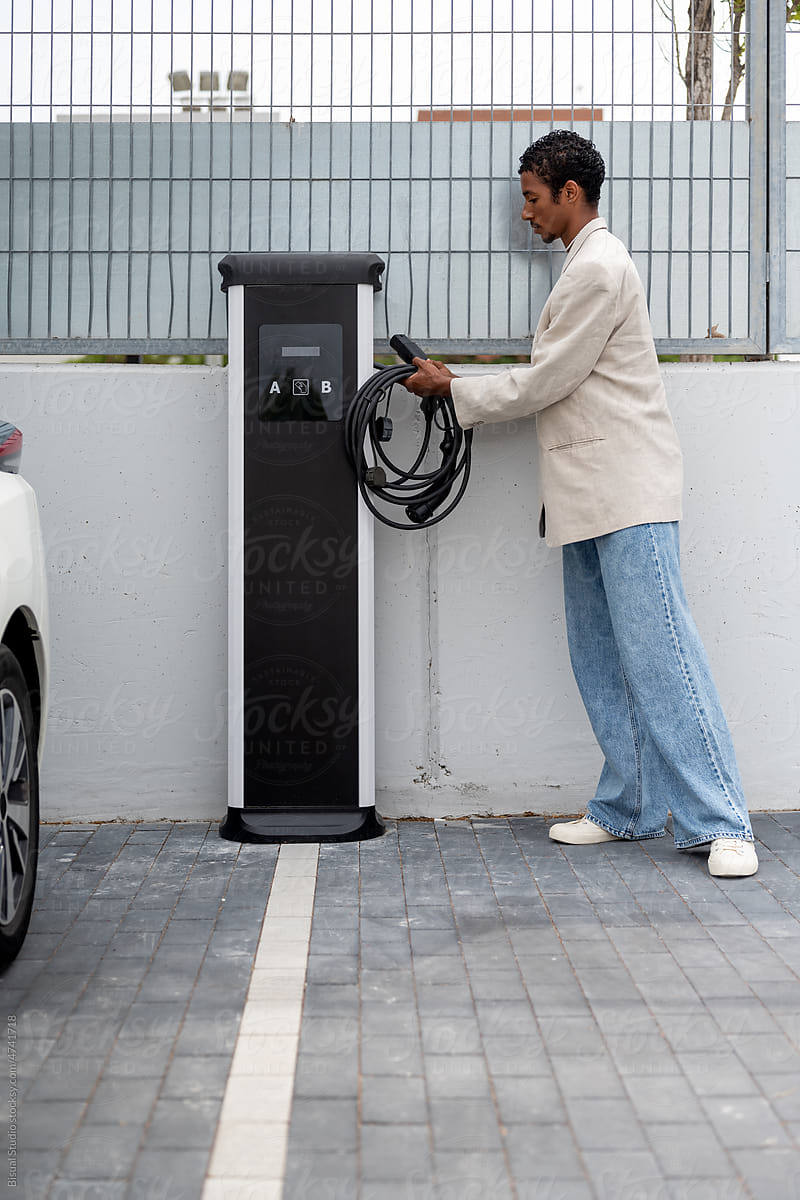 Black man charging his electric car